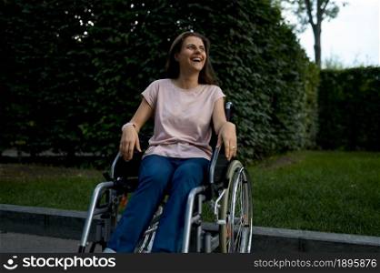 Handicapped woman in wheelchair. Paralyzed people and disability, handicap overcoming. Disabled female person walking in park. Handicapped woman in wheelchair, paralyzed people
