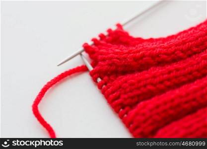 handicraft and needlework concept - close up of hand-knitted item with knitting needles. hand-knitted item with knitting needles