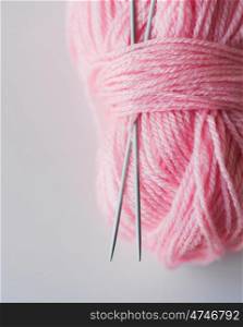 handicraft and needlework concept - close up of knitting needles and ball of pink yarn on white. close up of knitting needles and pink yarn ball