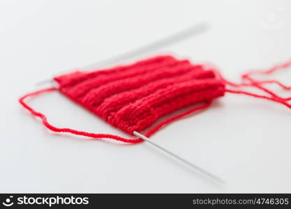 handicraft and needlework concept - hand-knitted item with knitting needles. hand-knitted item with knitting needles