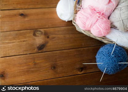 handicraft and needlework concept - wicker basket with knitting needles and balls of yarn. basket with knitting needles and balls of yarn