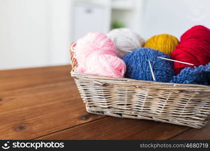 handicraft and needlework concept - wicker basket with knitting needles and balls of yarn. basket with knitting needles and balls of yarn