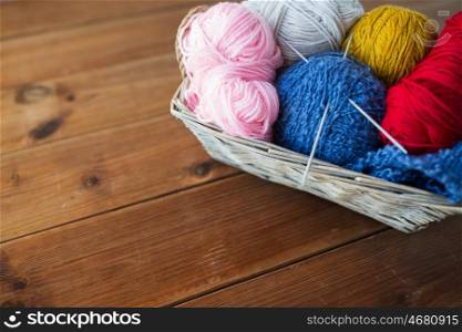 handicraft and needlework concept - wicker basket with knitting needles and balls of yarn. basket with knitting needles and balls of yarn