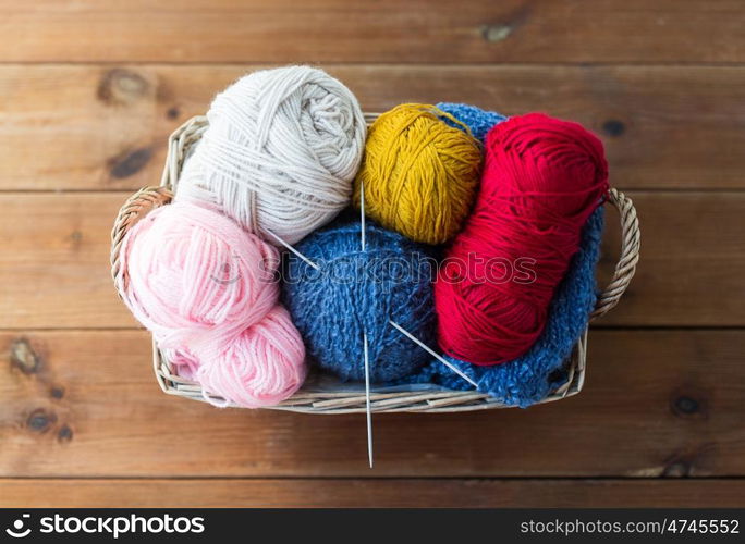 handicraft and needlework concept - wicker basket with knitting needles and balls of yarn. basket with knitting needles and balls of yarn