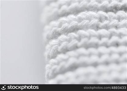 handicraft, knitwear and needlework concept - close up of white knitted item
