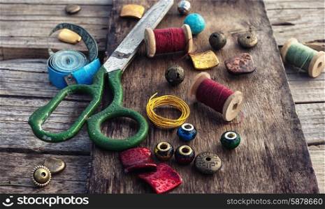 handicraft. outdated tools and jewelry for needlework on wooden background