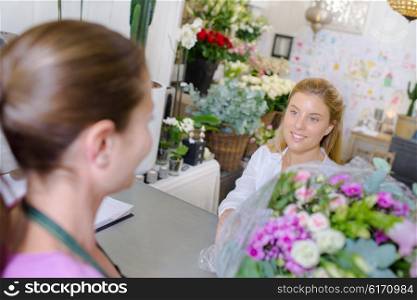 Handing a customer her flowers