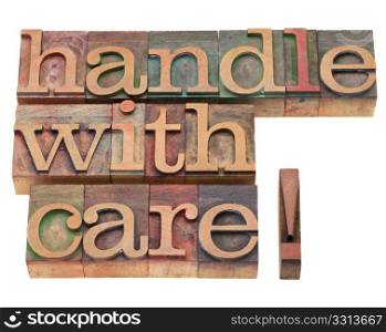 handle with care warning in vintage wood letterpress printing blocks, isolated on white