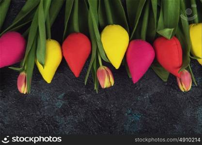 Handmade and real tulips on darken. Handmade and real tulips on darken concrete background for Mother&rsquo;s Day, spring time or Easter theme.