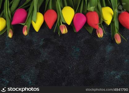 Handmade and real tulips on darken. Handmade and real tulips on darken concrete background for Mother&rsquo;s Day, spring time or Easter theme.