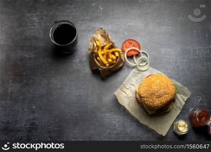 Handmade burger with fries and onion rings and coke