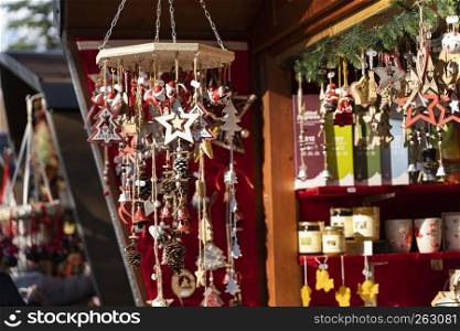 Handmade christmas decoration made out of wood, stars, christmas trees, bells, pinecone on a strap, on the christmas Market of Meran in South Tyrol Italy