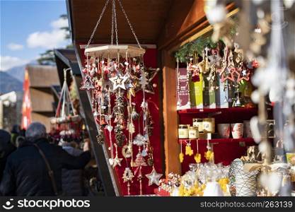 Handmade christmas decoration made out of wood, stars, christmas trees, bells, pinecone on a strap, on the christmas Market of Meran in South Tyrol Italy