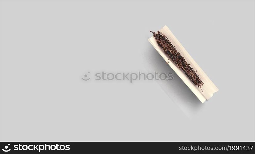 Handmade cigarette with pre-cut cigarette filter and tobacco paper. Close-up, top view