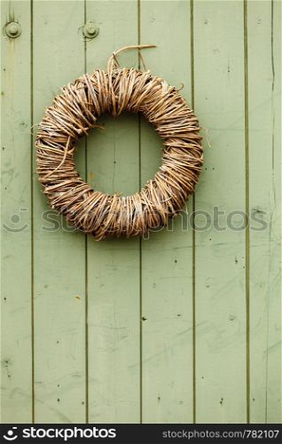Handmade decorative objects concept. Rounded wicker decoration hanging on wooden wall. Rounded wicker decoration hanging on wooden wall