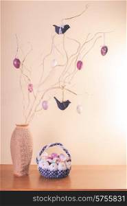 Handmade easter decorations on the branches in vase and textile basket. Handmade easter decorations