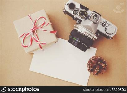 Handmade gift box and film camera on blank card with retro filter effect