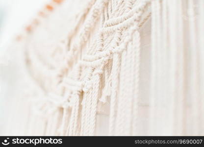 handmade macrame pattern a fragment of a wall panel in the boho style of beige cotton threads of natural color using the technique for home and wedding decor