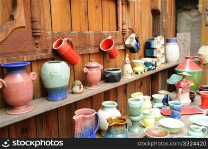 Handmade pottery on display in a rustic setting, vases, cups, bowls and other ceramic items.. Assorted Ceramic Pottery