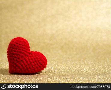 Handmade red yarn heart on gold abstract background. Copy space for text, Valentines day, love concept and love background