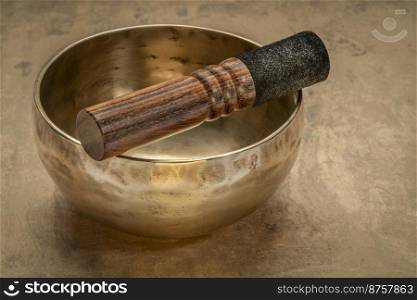 handmade tibetan singing bowl with a mallet on a textured bark paper, sound therapy for healing, relaxation and meditation