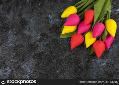 Handmade tulips on darken. Handmade tulips on darken concrete background for Mother&rsquo;s Day, spring time or Easter theme.
