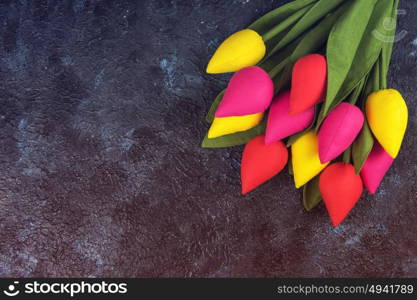 Handmade tulips on darken. Handmade tulips on darken concrete background for Mother&rsquo;s Day, spring time or Easter theme.
