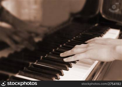 Hands above keys of the piano. A photo close up.Old color