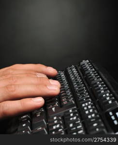 Hands above the keyboard. On a dark background, the black keyboard