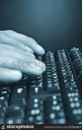 Hands above the keyboard. On a dark background, the black keyboard