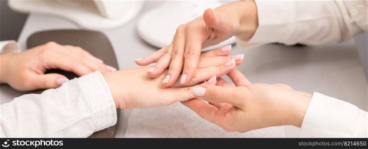 Hands and nails of young woman receiving oil massage by beautician at beauty salon.. Young woman receiving oil massage