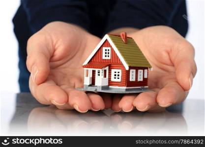 Hands and small house. Real estate or insurance concept.