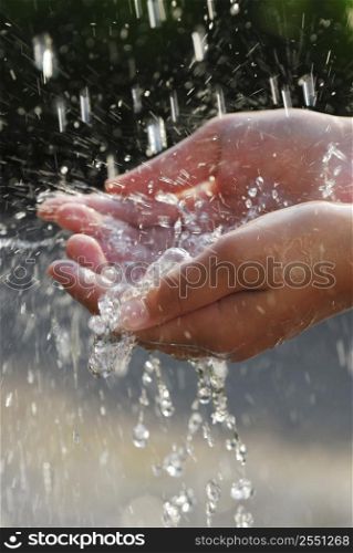 Hands catching clean falling water close up. Environmental concept.