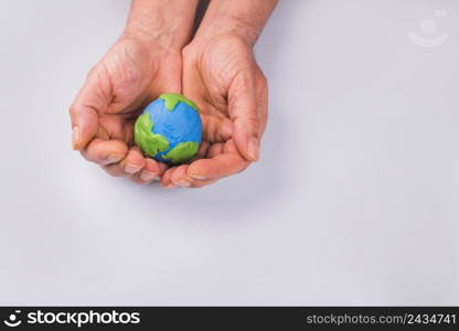 hands child holding colorful clay model planet earth