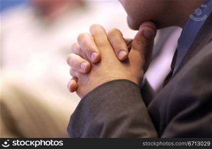 hands clasped under chin in meeting