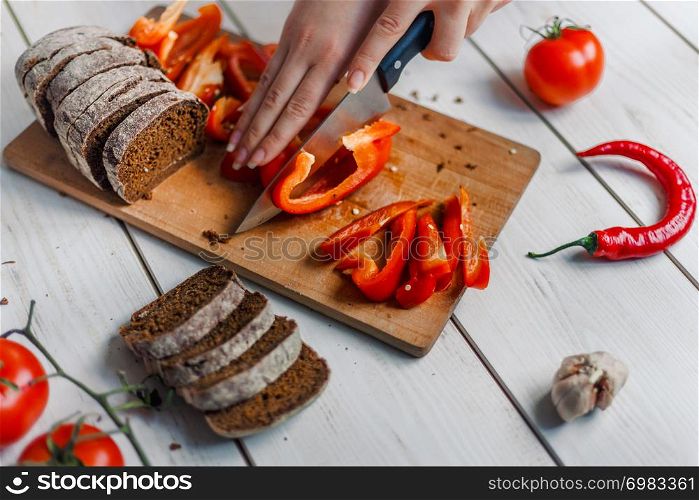 Hands cutting vegetables on kitchen blackboard