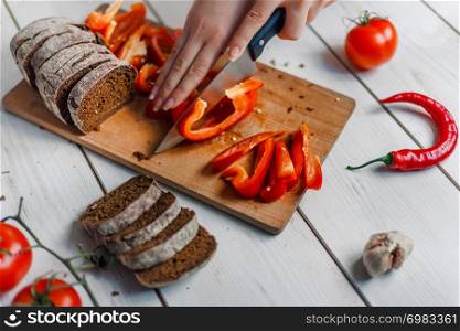 Hands cutting vegetables on kitchen blackboard
