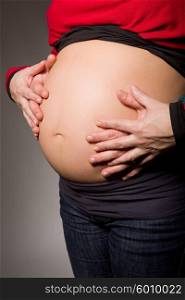 hands embrace a belly of the pregnant woman