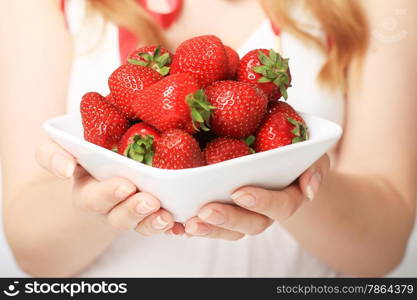 Hands giving a plate full of strawberry.