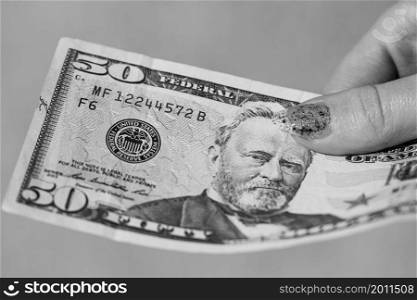 Hands giving money like a bribe or tips. Holding US dollars banknotes on a blurred background, US currency. Hands giving money like a bribe or tips. Holding US dollars banknotes on a blurred background, US currency