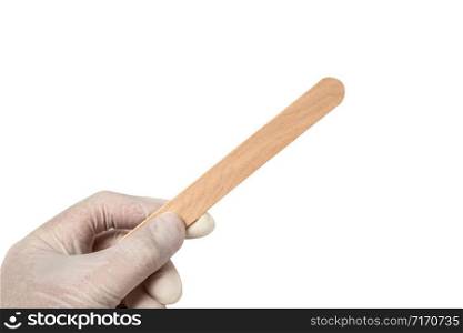 hands hold a sterile disposable eco friendly wooden medical spatula designed for examining the mouth and throat on a white isolated background