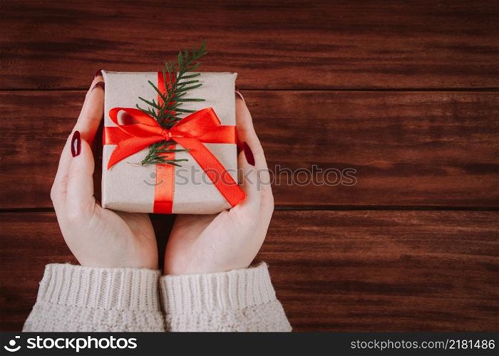 Hands hold beautiful gift box on a wooden background. Christmas tradition.. Hands hold beautiful gift box on wooden background. Christmas tradition.