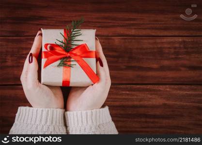 Hands hold beautiful gift box on a wooden background. Christmas tradition.. Hands hold beautiful gift box on wooden background. Christmas tradition.