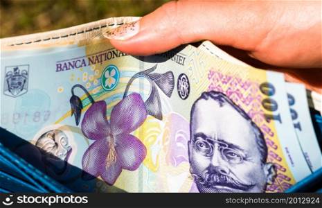 Hands holding and showing wallet with romanian money LEI.