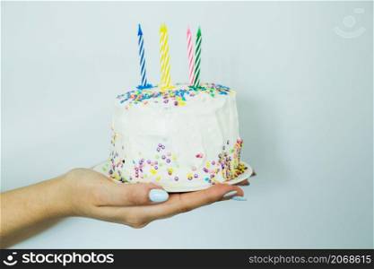 hands holding cake with sprinkles