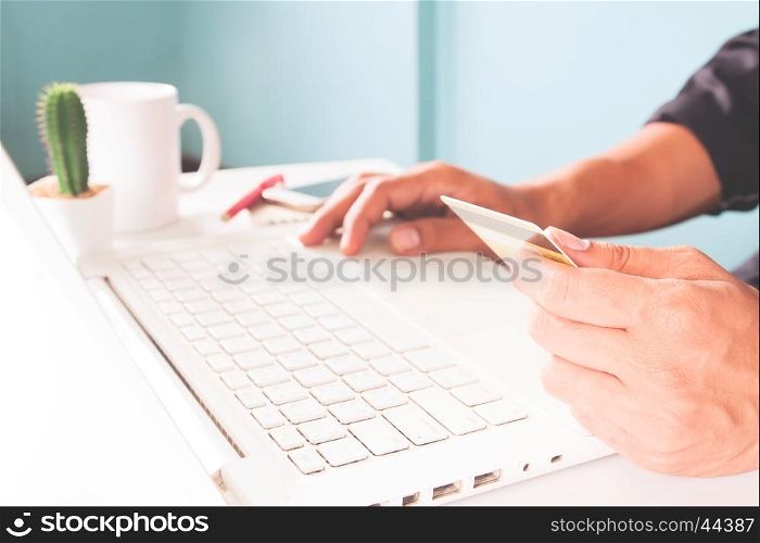 Hands holding credit cards and using laptop. Officer and business concept