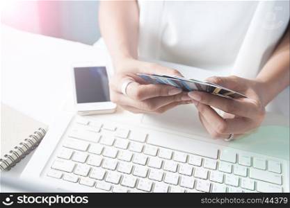Hands holding credit cards and using laptop. Online shopping