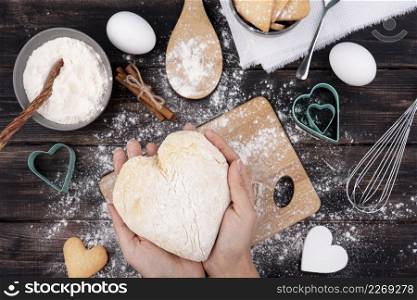 hands holding heart shaped dough