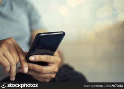 Hands holding mobile with blurred light background. Technology and business concept.