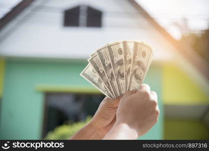 hands holding money to buy a house. real estate concept.